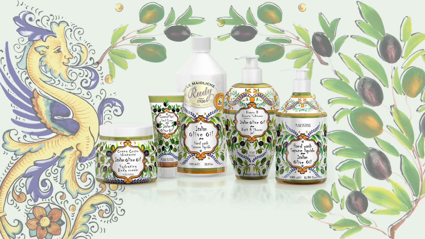 Le Maioliche di Rudy, collezione Olio d'oliva italiano. Rappresentati da sinistra a destra: Crema corpo 500ml, Crema mani 100ml, Ricarica sapone liquido 1L, Bagno e Docciaschiuma 700ml, Sapone liquido 500ml